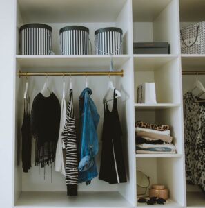 How to Organize a Small Closet Blue and Black Clothes Hanging in White Wooden Cabinet
