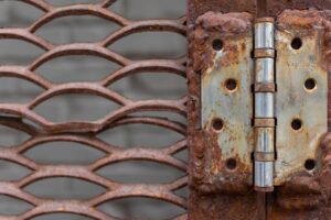 Old metal door hinge with weathered lattice