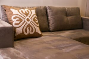 A close-up of an elegant gray sofa with an artistic decorative cushion in a modern living room.