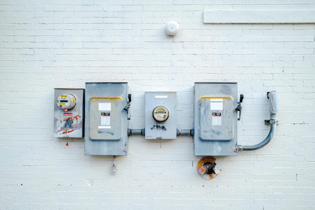 How to Lower Your Electricity Bill at Home Electrical Boxes on White Brick Wall in Chattanooga