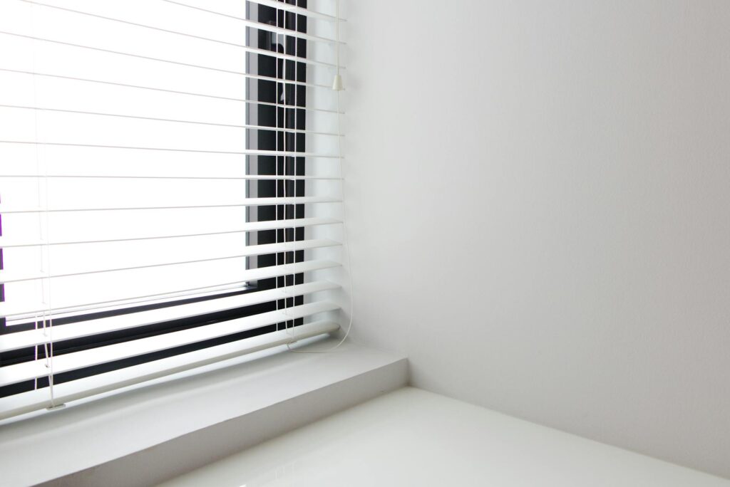 How to Clean Blinds Quickly Bright minimalist interior with white window blinds and smooth wall, perfect for modern design.