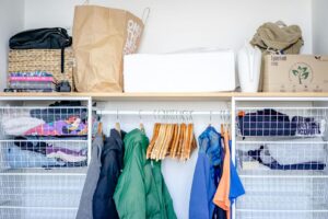 How to Store Seasonal Clothing Properly A minimalist open wardrobe featuring modern clothing, hangers, and storage baskets.