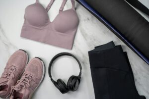 How to Wash Athletic Wear Properly Flat lay of pink sportswear and accessories for a fitness routine on marble.