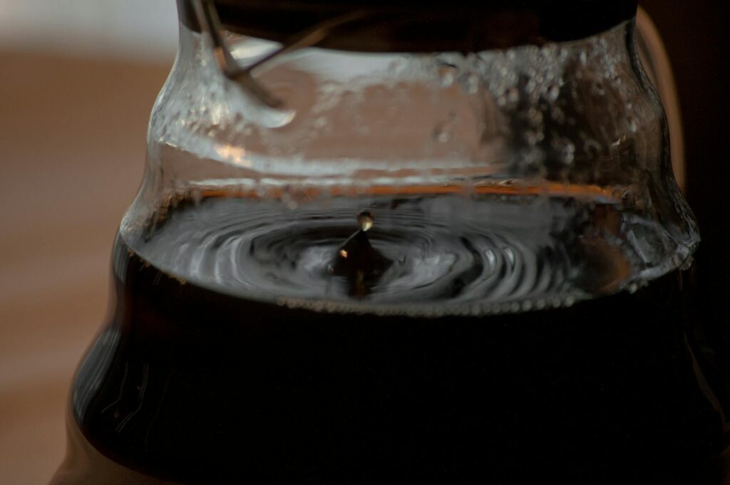Close-up view of a droplet in a coffee pot during brewing, capturing the essence of fresh coffee.