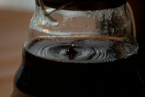 Close-up view of a droplet in a coffee pot during brewing, capturing the essence of fresh coffee.