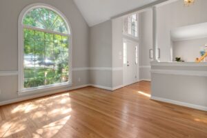 How to Maintain Floors with Minimal Effort Bright living room with large window and hardwood floors, perfect for residential spaces.