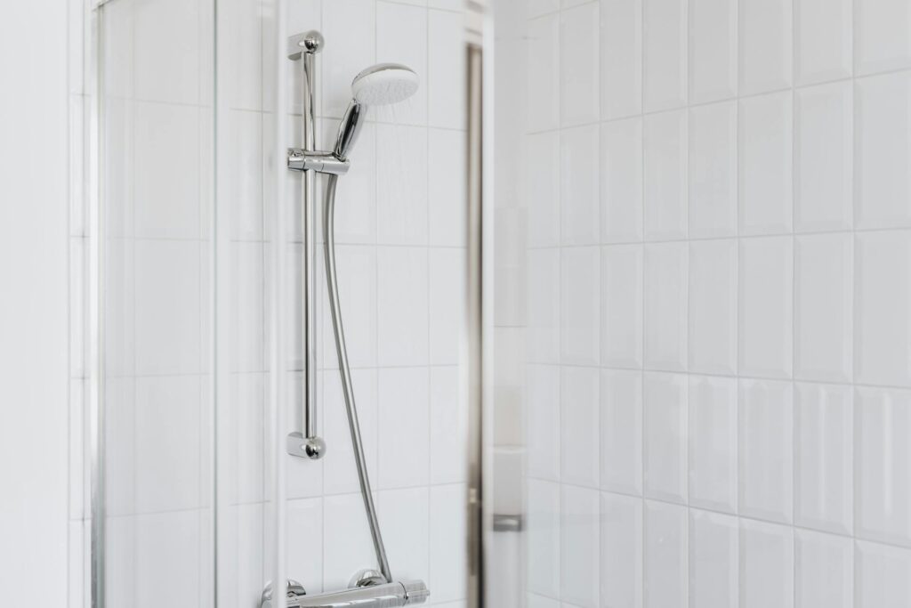 How to Replace a Showerhead Stylish shower setup with chrome fixtures and clean white tiles.
