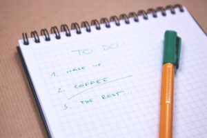 How to Set Up a Seasonal Cleaning Routine Handwritten to-do list on graph paper notebook with pen. Ideal for organizing tasks.