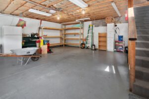 How to Organize a Garage Without Remodeling Spacious garage interior with storage shelves, tools, and a wheelbarrow, ideal for home organization.